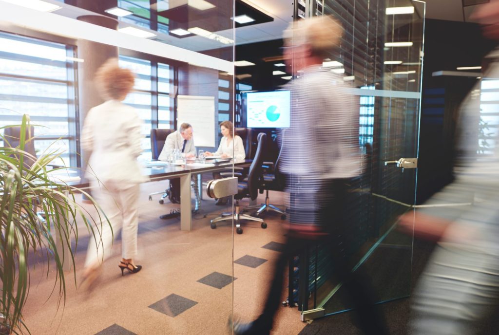 Local officials walking through glass door in government office